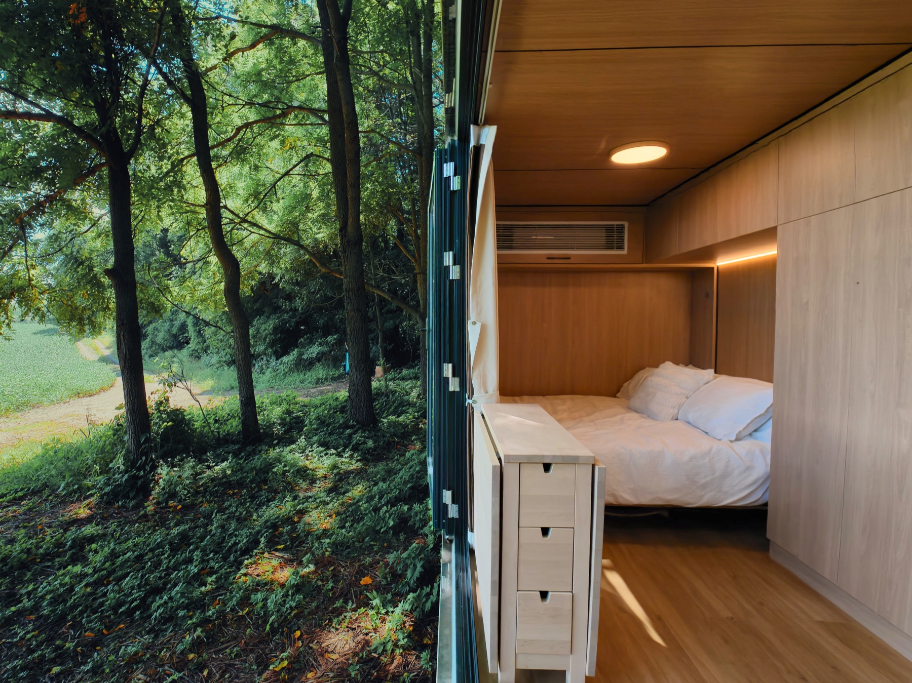 REFLECT mirror cabin open to the forest — woodland on the left, warm wood interior on the right, near Drumbo Ontario