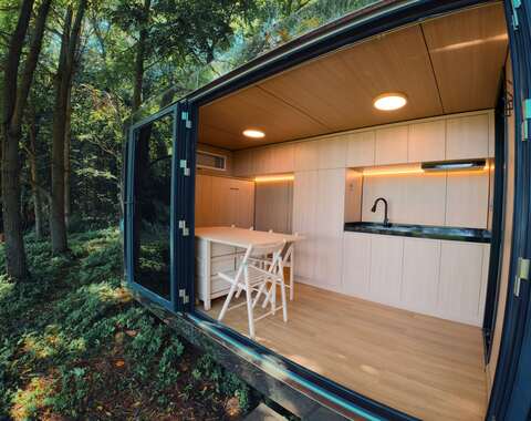 Wide exterior shot of reflective tiny cabin for sale